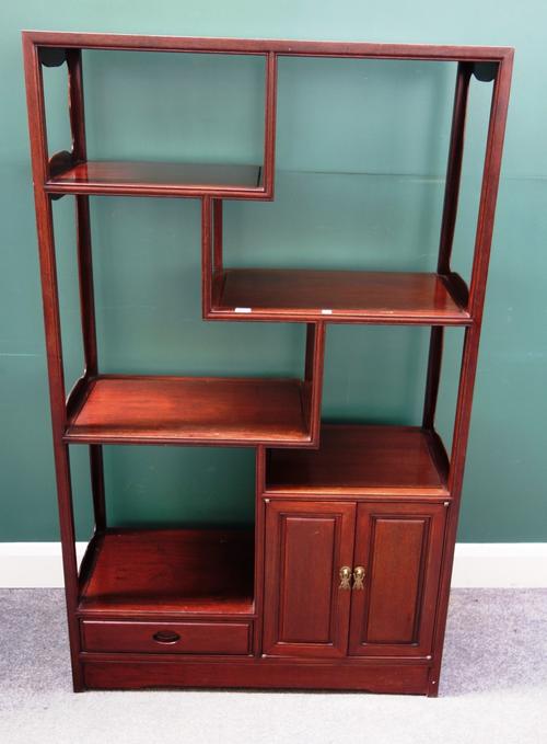 An early 20th century Chinese hardwood side cabinet, with five open tiers over cupboard and drawer, 92cm wide x 153cm high.