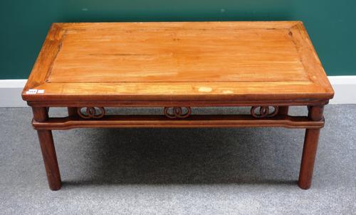 A late 19th/early 20th century Chinese hardwood low rectangular table, with pierced and carved frieze, on turned supports, 100cm wide x 46cm high.