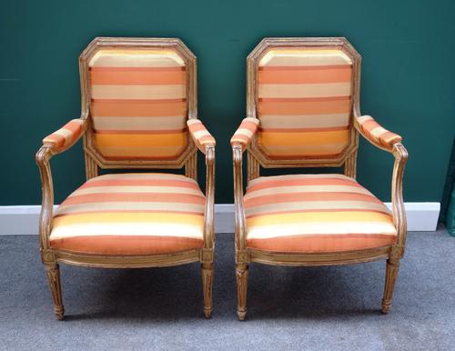 A pair of Louis XVI style open armchairs, with compressed octagonal backs on fluted supports, 59cm wide x 91cm high, (2).