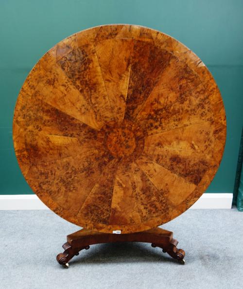 A William IV pollard oak centre table, the circular radial veneered snap top on turned column and triform platform, 124cm diameter.