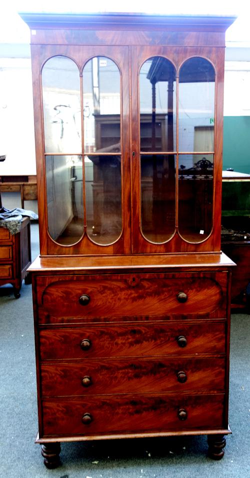 An early Victorian mahogany secretaire bookcase chest, with pair of glazed doors over fitted drawer and three further long drawers, on turned feet, 10