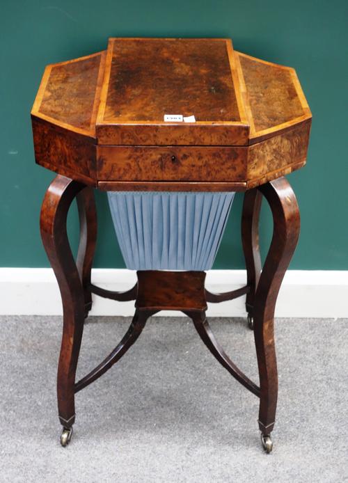 An early Victorian figured yew satinwood banded triple lift-top work table, with pull-out wool box, on four shaped supports, 52cm wide x 79cm high.