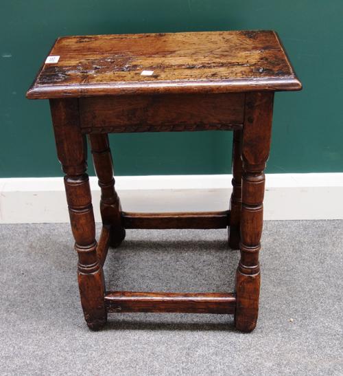 A 17th century oak joint stool, on turned supports united by perimeter stretcher, 45cm wide x 58cm high.
