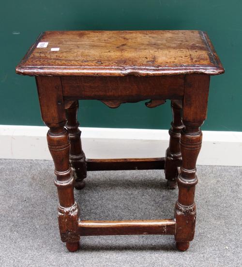 A Charles I and later oak joint stool, with shaped frieze, on baluster turned supports united by perimeter stretcher, 38cm wide x 56cm high.