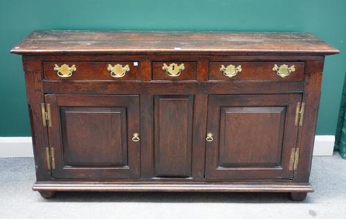 A mid-18th century oak dresser base, with three drawers over a pair of cupboards, on stile feet, 165cm wide x 88cm high.