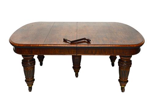 Lamb of Manchester; a large Victorian figured and bog oak extending dining table, the rounded rectangular top on five tapering fluted columns, 145cm w