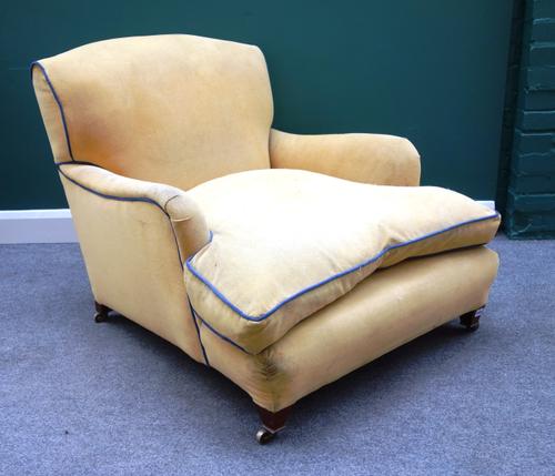 A Howard style early 20th century easy armchair, with deep seat, on tapering square supports, 86cm wide x 80cm high.