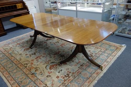 A George III style mahogany twin pedestal extending dining table, on six downswept supports, to include two extra leaves, 107cm wde x 172cm long, 268c