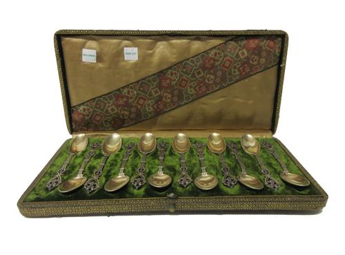 A set of twelve French gilt teaspoons, the handles with cast and pierced decoration, cased, a set of six Norwegian, gilt and enamelled coffee spoons,