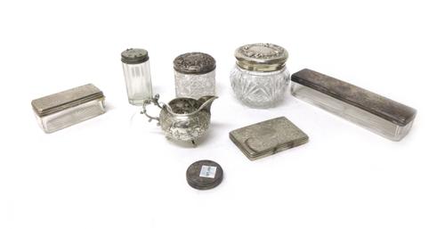 A Dutch cream jug, decorated with cows and windmills within scrolling borders and raised on three feet, four silver lidded glass toilet bottles and ja