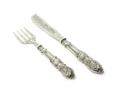 A pair of Victorian silver fish servers, with pierced and scroll engraved decoration, Birmingham 1852, with loaded silver handles, Sheffield (date wor