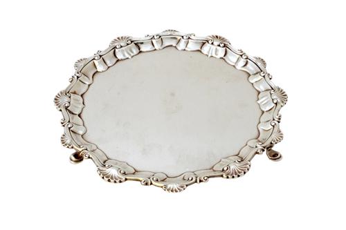 An early George III silver salver, of shaped circular form, having a shell and pie-crust rim in the Chippendale style, raised on three pad feet, maker
