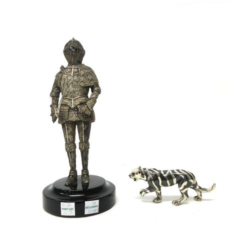 A cast model of a tiger detailed 800 and a filigree model of a soldier in armour, with a sword and a shield, raised on a circular ebonised base, overa