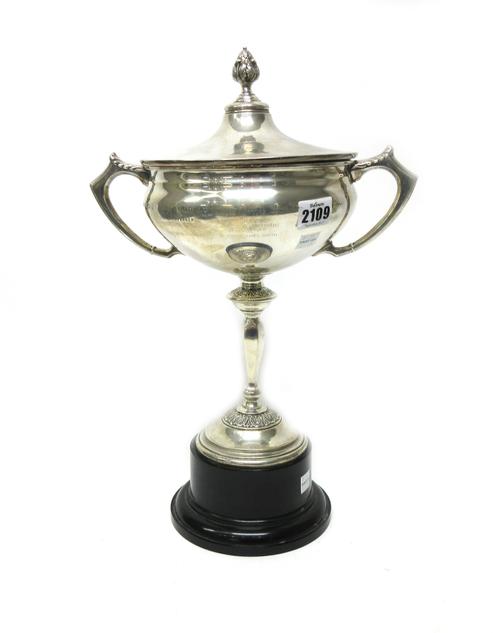 A silver twin handled trophy cup and lid, decorated with cast bands and with a cast finial to the lid, detailed Electrical Industries Club Golf Cup, B
