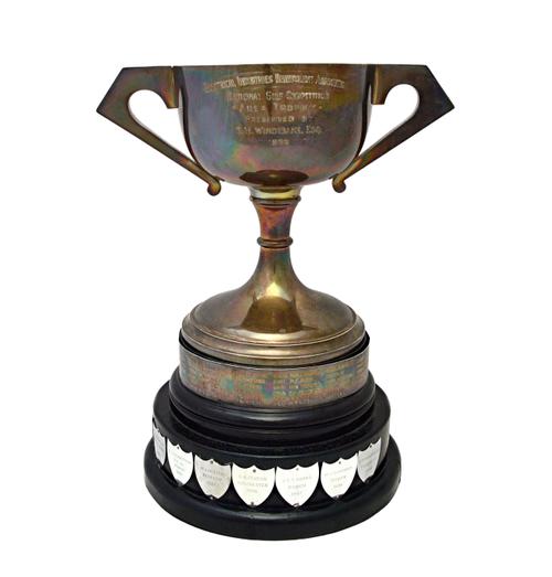 A silver twin handled trophy cup, detailed Electrical Industries Benevolent Association, raised on a circular foot, with an ebonised two tier stand, f