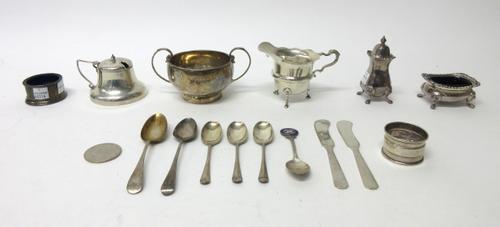 Silver, comprising: a twin handled sugar bowl, Birmingham 1932, a cream jug raised on three feet, Birmingham 1919, a salt with a blue glass liner, a m