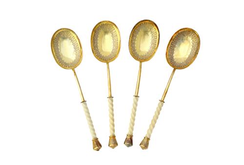 A set of four Victorian silver gilt dessert or fruit serving spoons, each with a curved oval bowl having engraved decoration, with a carved ivory spir