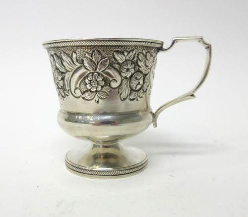 A George IV silver christening mug, embossed with flowers and foliate scrolls within a decorated rim, later engraved May 22nd 1864, London 1821, heigh