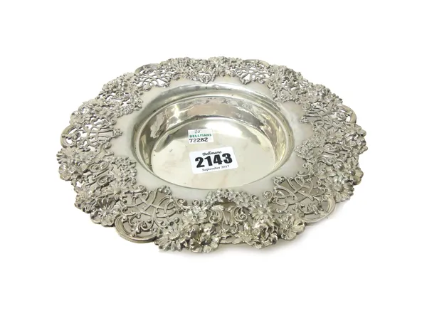 A Sterling dish of shaped circular form, the border cast and pierced with floral, foliate and scrolling decoration, diameter 19cm, weight 180 gms.