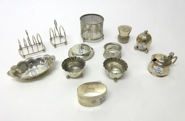 Silver and silver mounted wares, comprising; a three bar toast rack, a five bar toast rack, a frame and cover to hold a preserve jar, a mustard pot wi