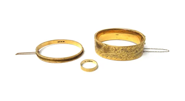 A 9ct gold oval hinged bangle, the front with floral and foliate engraved decoration, on a snap clasp, a gold oval hinged bangle, engine turned to the