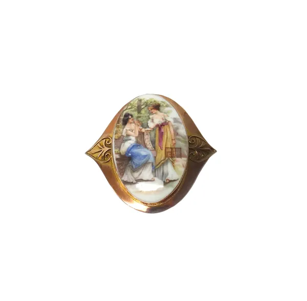 A gold mounted oval ceramic brooch, decorated with two figures of ladies in a garden scene, within a shaped oval surround, detailed 9 CT W.N.  Illustr