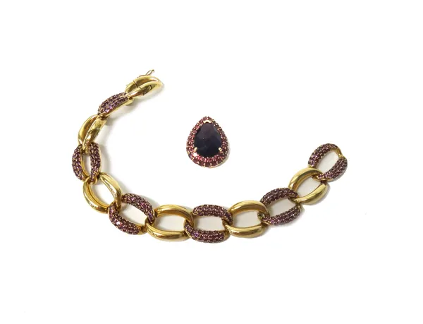 A 9ct gold and red gem set oval link bracelet, in a twist link design, on an integral folding clasp, length 19cm and a 9ct gold pendant in a similar d