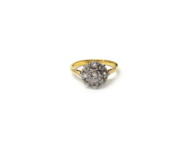A gold and platinum, diamond set nine stone cluster ring, claw set with the principle cushion shaped diamond at the centre, in a surround of eight sma