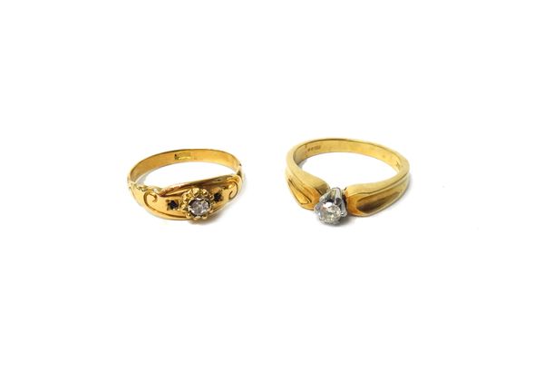 An 18ct gold and diamond single stone ring, claw set with the circular cut diamond in a raised design, between C shaped shoulders, ring size N and a g