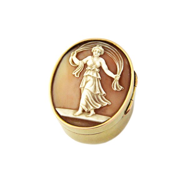 An oval hinge lidded box, the cover mounted with an oval shell cameo, carved as a dancing girl, detailed to the underside St Moritz Juli 1896, the rim