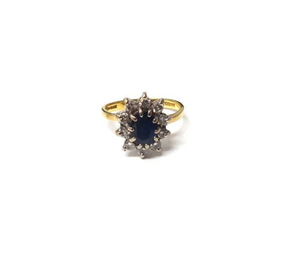 An 18ct gold, sapphire and diamond oval cluster ring, claw set with the oval cut sapphire at the centre, within a surround of circular cut diamonds, r