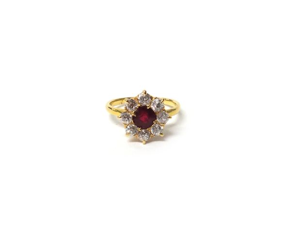 A gold, ruby and diamond set nine stone cluster ring, mounted with the cushion shaped ruby at the centre, in a surround of eight cushion shaped diamon