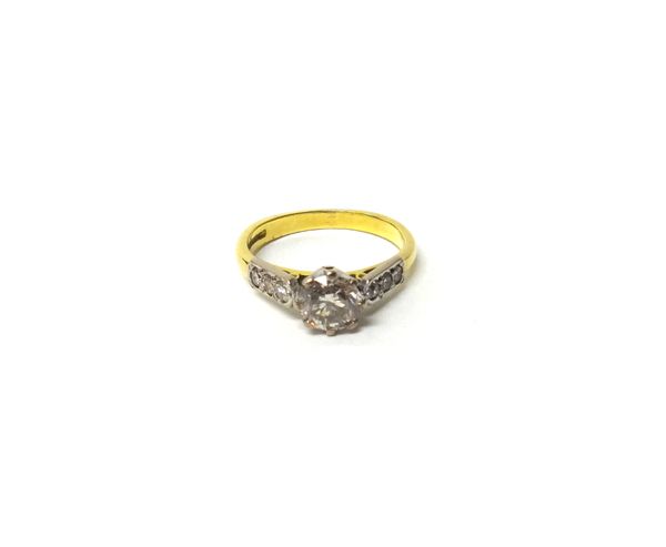 An 18ct gold and diamond ring, claw set with the principle circular cut diamond at the centre, between diamond three stone shoulders, ring size K.