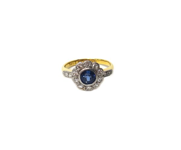 A gold and platinum, sapphire and diamond set cluster ring, mounted with the cushion shaped sapphire at the centre, in a surround of cushion shaped di