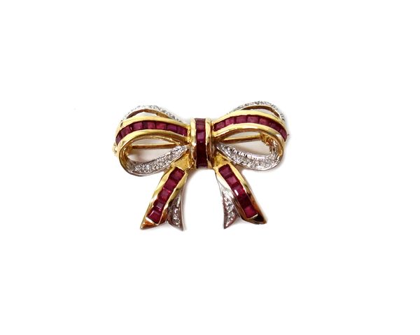 A 9ct gold, ruby and diamond brooch designed as a ribbon tied bow, mounted with calibre cut rubies and with small circular cut diamonds, with a case.