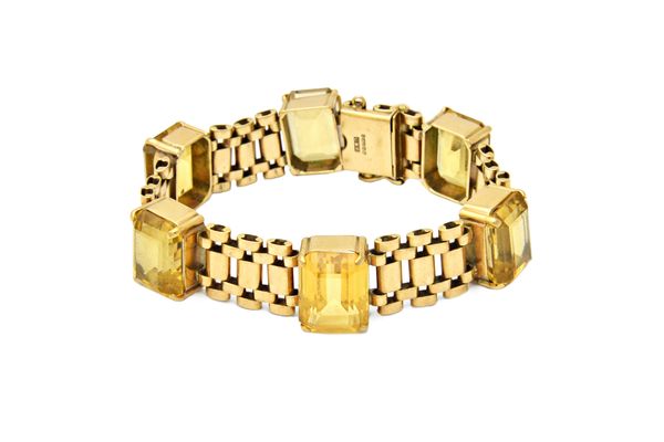 A 9ct gold and citrine bracelet in a wide oval link design, claw set with six cut cornered rectangular step cut citrines, on a snap clasp, Birmingham