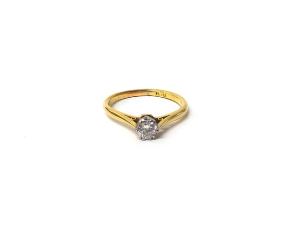 A gold and diamond set single stone ring, claw set with a circular cut diamond, detailed 18 CT, ring size P and a half, with a case.