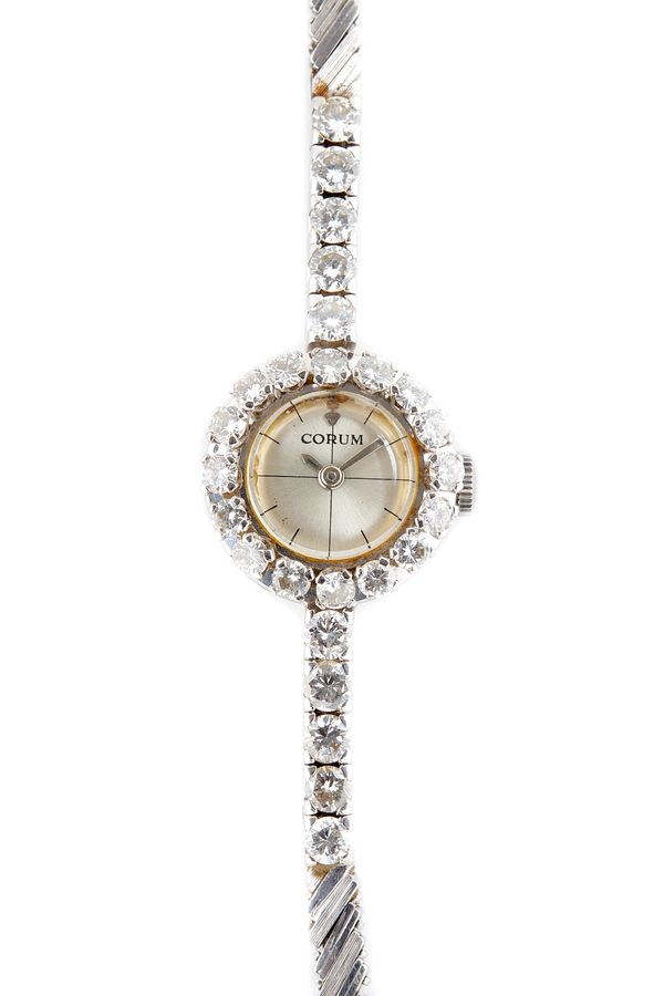 A lady's white gold and diamond set Corum bracelet wristwatch, the signed circular silvered dial with baton shaped numerals, the bezel and the bracele