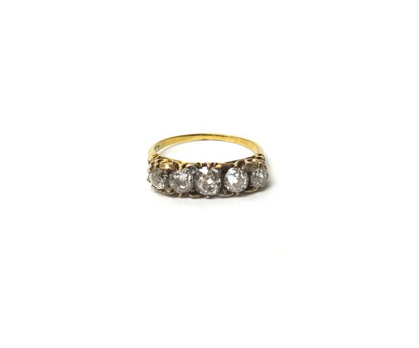 A gold and diamond five stone ring, mounted with a row of cushion shaped diamonds, graduating in size to the centre stone and with further diamond poi