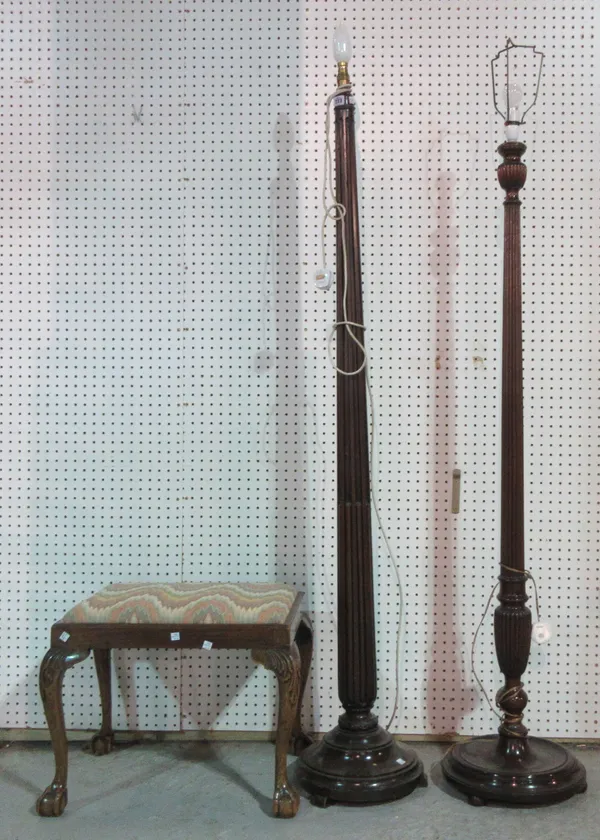 A 19th century mahogany standard lamp, with fluted column, another with gadrooned column and a walnut framed footstool on ball and claw feet, (3).  G1