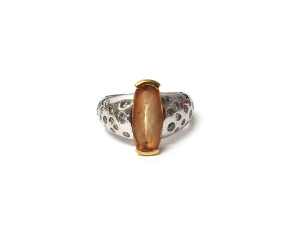 A topaz and diamond ring, mounted with the oval cut topaz at the centre, between circular cut diamond set shoulders in an abstract design, ring size Q