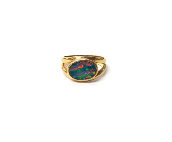 A gold and opal single stone ring, mounted with an oval opal between split shoulders, detailed 750, gross weight 4.6g ring size M 1/2.