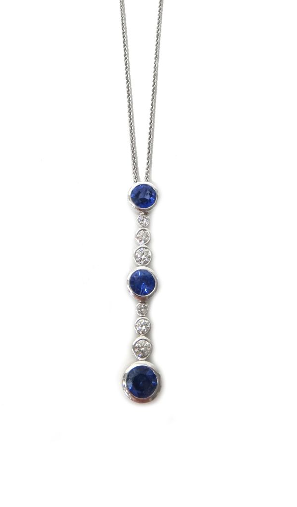 A sapphire and diamond pendant, collet set with three circular cut sapphires and with two rows of three graduated circular cut diamonds at intervals,