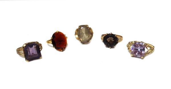 A 9ct gold ring, claw set with an oval cut smoky quartz, a 9ct gold ring, claw set with an oval cut garnet, a 9ct gold ring, claw set with a rectangul