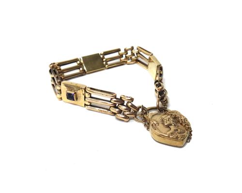 A gold and amethyst set bar and oval link gate bracelet, having three rectangular amethyst set panels at intervals, on a gold heart shaped padlock cla
