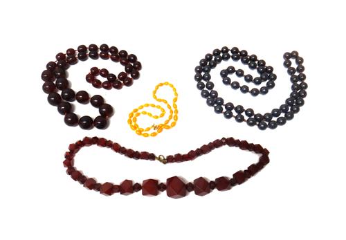A single row necklace of graduated reconstituted semi-translucent amber beads, a single row necklace of reconstituted dark amber beads, a single row n