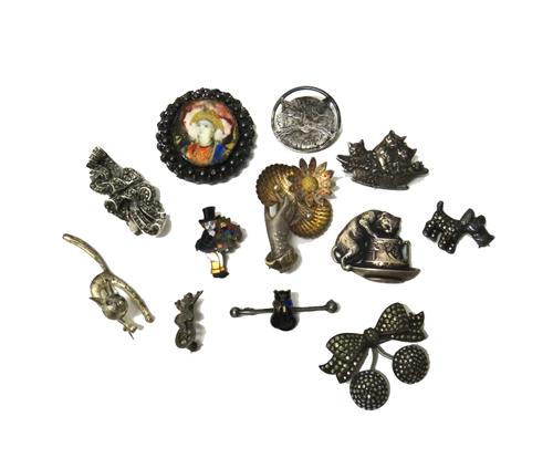 A late 19th century brooch designed as a hand holding two sea shells, each mounted with an imitation pearl and with a flower to the side, a marcasite