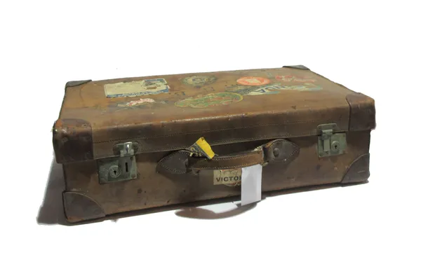 A 20th century brown leather suitcase, a gilt metal table lamp, a copper 'helmet' coal scuttle and a steel and wire mesh folding fire guard, (4).  S2B