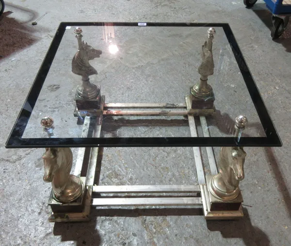 A 20th century glass and metal low coffee table, with horse head supports, 65cm square wide x 39cm high. J5