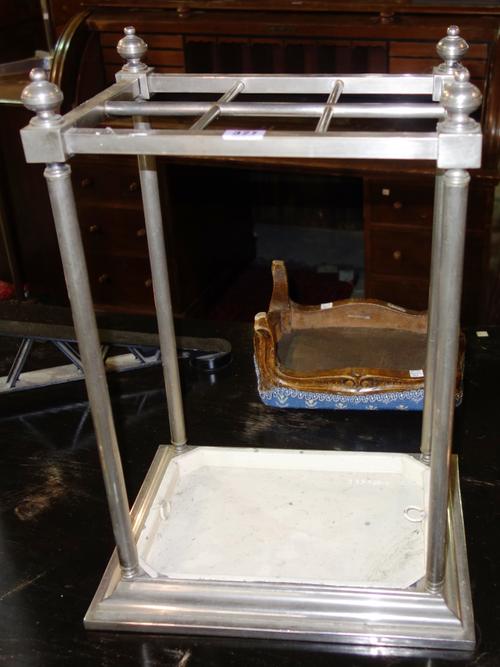 A 20th century steel umbrella/ stick stand, with six divisions on a stepped rectangular base and removable pan, 35cm wide. G8